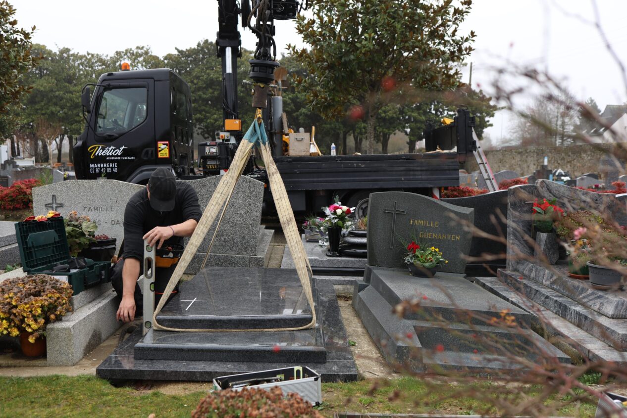 La pose de la pierre tombale dans le cimetière 